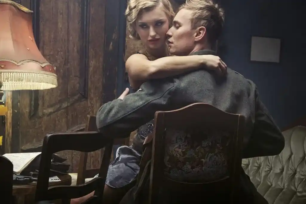 Couple enlacé dans une chambre à l’ambiance tamisée, entre intimité et passion. Illustration de la nouvelle « L’Amour charnel, au lit ou ailleurs » d’Hervé Gransart.