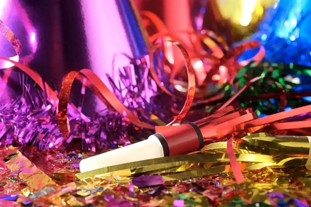 Serpentins, confettis et accessoires de fête multicolores en gros plan. Illustration de la chronique « Les Décorations » d’Hervé Gransart.