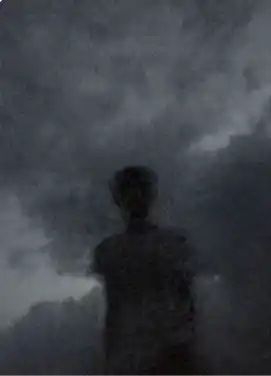 Silhouette sombre d’un homme de dos, noyée dans la brume et les nuages. Illustration du texte « Où es-tu » d’Hervé Gransart